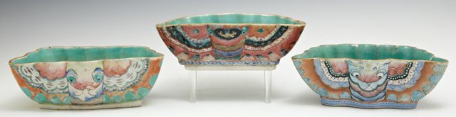 Group of Three Chinese Trapezoidal Glazed Earthenware B: Group of Three Chinese Trapezoidal Glazed Earthenware Bowls, early 20th c., of lobed form, with bright polychromed decoration, two with stamped red marks on the bottoms, each on a custom made carved h