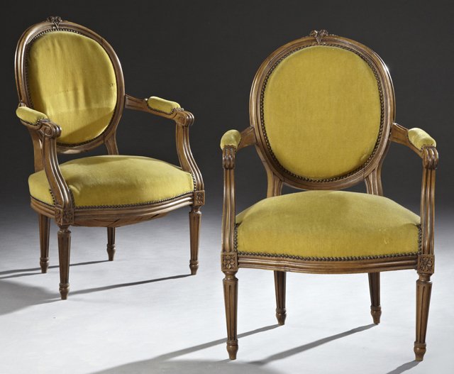 Pair of Louis XIV Style Carved Beech Fauteuils, early: Pair of Louis XIV Style Carved Beech Fauteuils, early 20th c., with a floral carved crest over an oval medallion back, to upholstered reeded arms, above a bowed seat, on tapered reeded legs, to French
