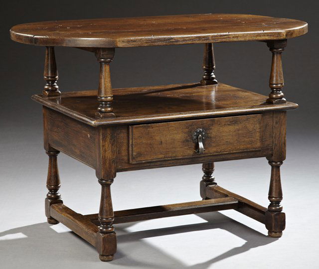 French Provincial Louis XIII Style Carved Oak Two Tier: French Provincial Louis XIII Style Carved Oak Two Tier Server, 19th c., the oval shaped three plank top on turned tapered supports, over an open shelf, above a single frieze drawer with a wrought iron