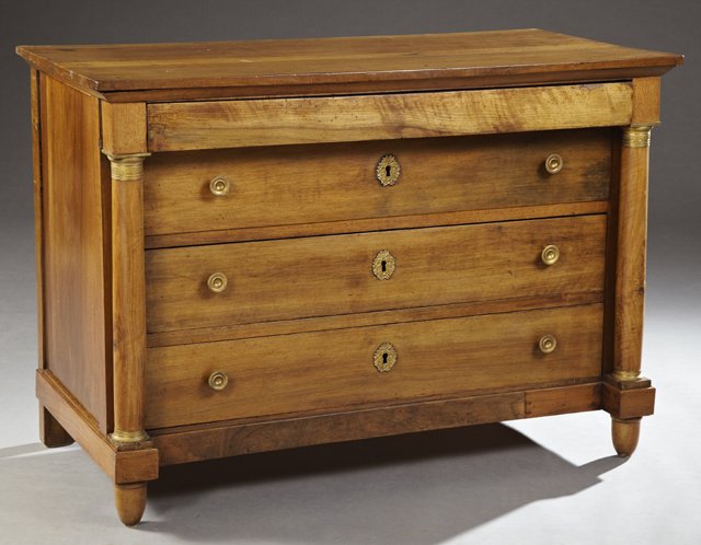 French Empire Style Ormolu Mounted Carved Walnut Commod: French Empire Style Ormolu Mounted Carved Walnut Commode, 19th c., the rectangular top over a frieze drawer above three setback drawers with wreath form escutcheons, flanked by ormolu mounted turned t