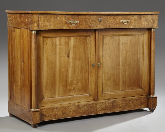 French Empire Ormolu Mounted Carved Walnut Sideboard,: French Empire Ormolu Mounted Carved Walnut Sideboard, 19th c., the rectangular top over a long burled walnut frieze drawer, above double cupboard doors flanked by ormolu mounted stiles to tapered squa