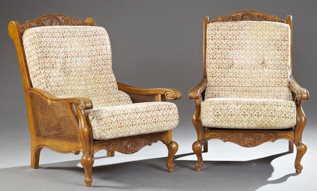 Pair of French Louis XV Style Carved Birch Caned: Pair of French Louis XV Style Carved Birch Caned Bergeres, 20th c., the arched crest over a cane back with loose cushions within cane sided arms, to cabriole legs on scrolled feet, joined by a foliate