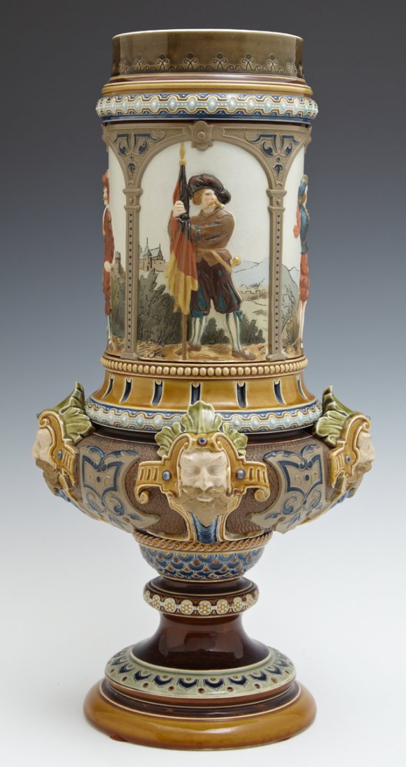Mettlach Pokal, c. 1890, #1820, by Villeroy and Boch,: Mettlach Pokal, c. 1890, #1820, by Villeroy and Boch, with four figural panels above four relief masks, now lacking the lid, H.- 14 in., Dia.- 7 1/4 in. Note: This Piece is Illustrated in the "Book of