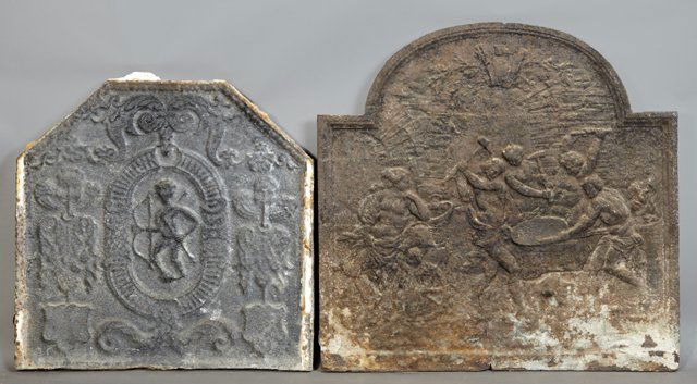 Two French Cast Iron Fire Backs, early 19th c., the: Two French Cast Iron Fire Backs, early 19th c., the first example with an arched back with relief decoration of blacksmiths, the second example with a relief decoration of a winged Eros with bow and a