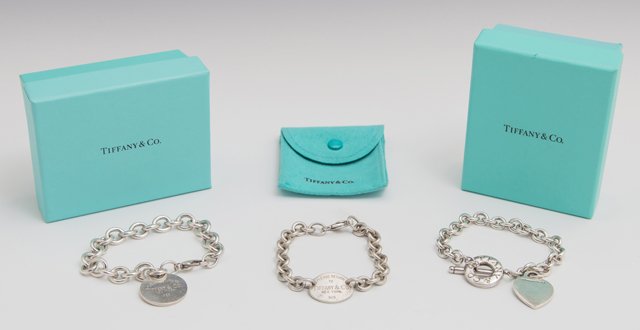 Three Tiffany & Co. Sterling Link Bracelets, one with a: Three Tiffany & Co. Sterling Link Bracelets, one with a heart, two with "Return to Tiffany & Co." tags, with two original boxes. (3 Pcs.)