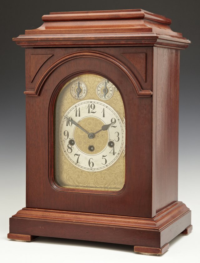 German Carved Mahogany Bracket Clock, 20th c., time and: German Carved Mahogany Bracket Clock, 20th c., time and strike, imported by George Kuehl and Co, Chicago, H.- 15 3/4 in., W.- 11 7/8 in., D.- 8 in.