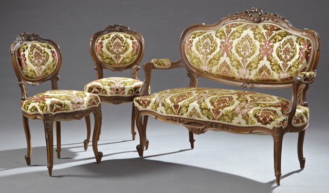 Three Piece Louis XV Style Carved Walnut Salon Suite,: Three Piece Louis XV Style Carved Walnut Salon Suite, 19th c., consisting of two side chairs and a settee, with rocaille and floral carved arched crests over upholstered backs above bowed seats on car