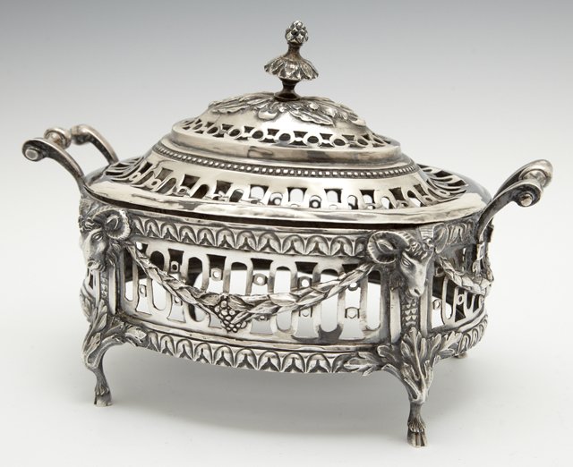 Silver Covered Dresser Box, 1795, Germany, with: Silver Covered Dresser Box, 1795, Germany, with reticulated lid and sides, the sides with garland draperies, with four ram's head sides terminating in hoof feet, now lacking the glass liner, Wt.- 12 t