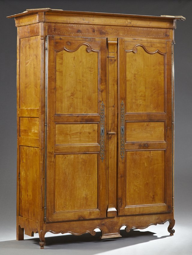 Monumental Inlaid Carved Cherry Louis XV Style Armoire,: Monumental Inlaid Carved Cherry Louis XV Style Armoire, early 19th c., the ogee canted corner crown above an inlaid frieze over two triple paneled doors with long iron escutcheons, separated by a reli