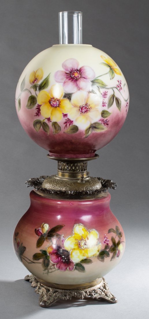 American Brass and Glass Gone with the Wind Lamp, c.: American Brass and Glass Gone with the Wind Lamp, c. 1900, with a floral painted ball shade over a repousse brass font, on a baluster floral milk glass body on a pierced brass foot, with chimney, now 