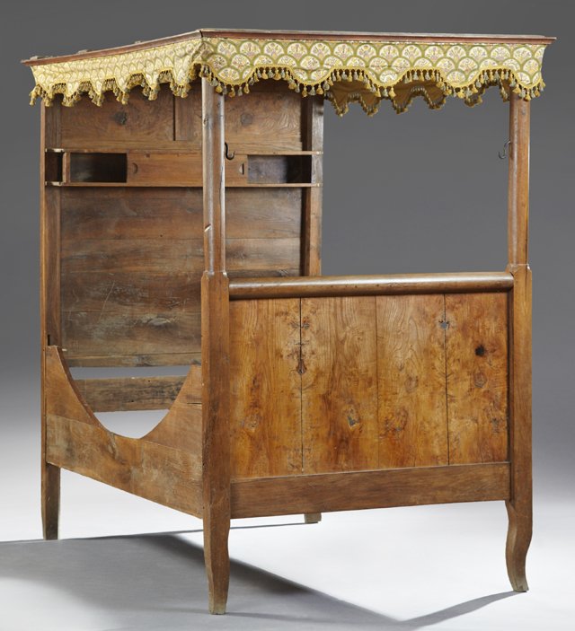 French Provincial Carved Elm and Oak Tester Bed, early: French Provincial Carved Elm and Oak Tester Bed, early 19th c., the headboard with a sliding door shelf flanked by square posts, to a rounded top footboard within rounded posts, on flat cabriole legs,