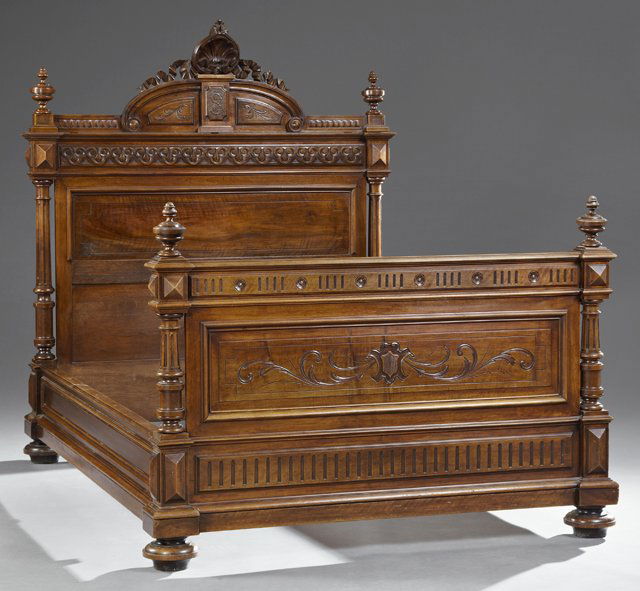 French Henri II Style Carved Walnut Bed, 19th c., the: French Henri II Style Carved Walnut Bed, 19th c., the arched crest monogrammed "SL," over an inset panel headboard flanked by turned fluted columns, to turned feet joined to a footboard with turned ur