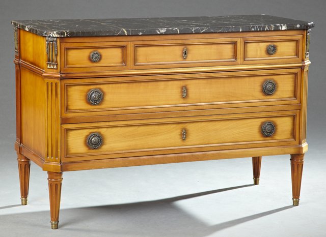 French Louis XVI Style Carved Cherry Marble Top: French Louis XVI Style Carved Cherry Marble Top Commode, 20th c., the canted corner highly figured black marble over three graduated drawers, flanked by ormolu mounted chamfered fluted stiles on ring 