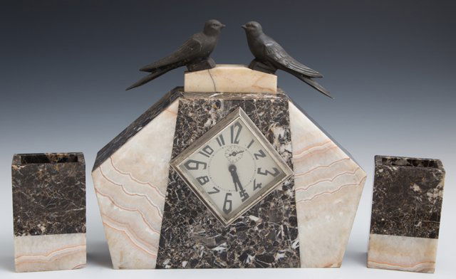 Art Deco Three Piece Marble Clock Set, c. 1940, the: Art Deco Three Piece Marble Clock Set, c. 1940, the geometric alarm clock with patinated spelter bird surmounts, together with a pair of highly figured marble garnitures, Clock- H.- 11 5/8 in., W.- 13