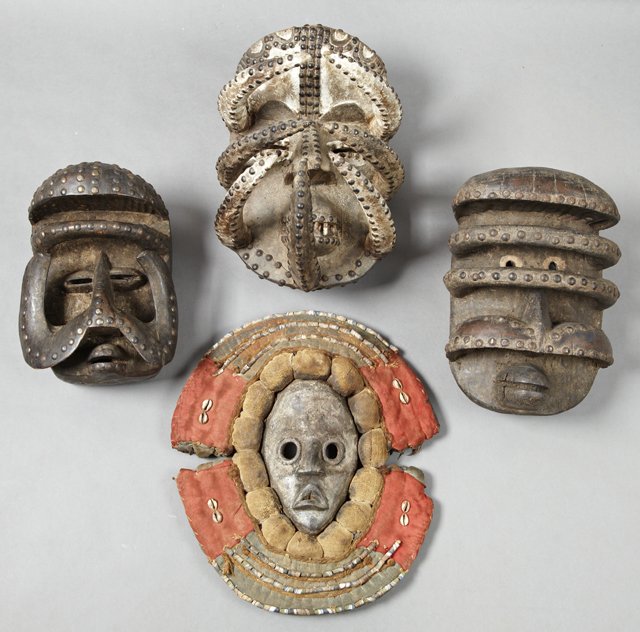 Group of Four African Masks, 20th c., three with iron: Group of Four African Masks, 20th c., three with iron tack decoration, the fourth of wood with wide cloth collar decoration with beads and cowry shells, Cloth- H.- 18 in., W.- 15 1/2 in., D.- 3 1/2 in