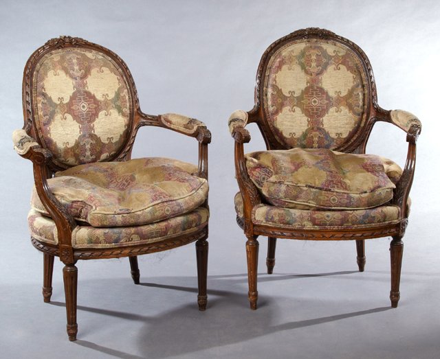 Pair of French Louis XVI Style Carved Beech Fauteuils,: Pair of French Louis XVI Style Carved Beech Fauteuils, mid 19th c., the carved crests over oval medallion upholstered backs above circular seats with shaped cushions within upholstered scrolled arms t