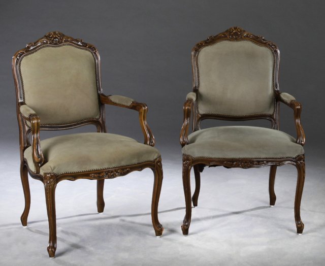 Pair of French Louis XV Style Carved Beech Fauteuils,: Pair of French Louis XV Style Carved Beech Fauteuils, 20th c., the arched flower carved crest rails over shield form backs above bowed seats within upholstered arms on cabriole legs to scroll feet joi