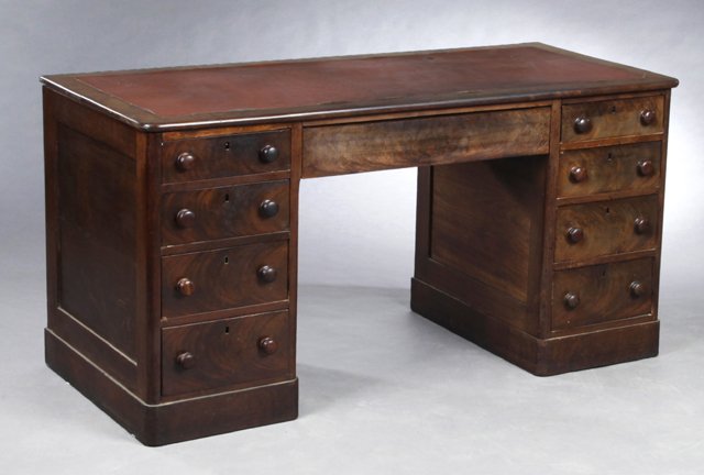 English Victorian Carved Mahogany Leather Top Partner's: English Victorian Carved Mahogany Leather Top Partner's Desk, late 19th c., the inset red leather top over a frieze drawer flanked by two pedestals, with four graduated drawers each, on a plinth base,