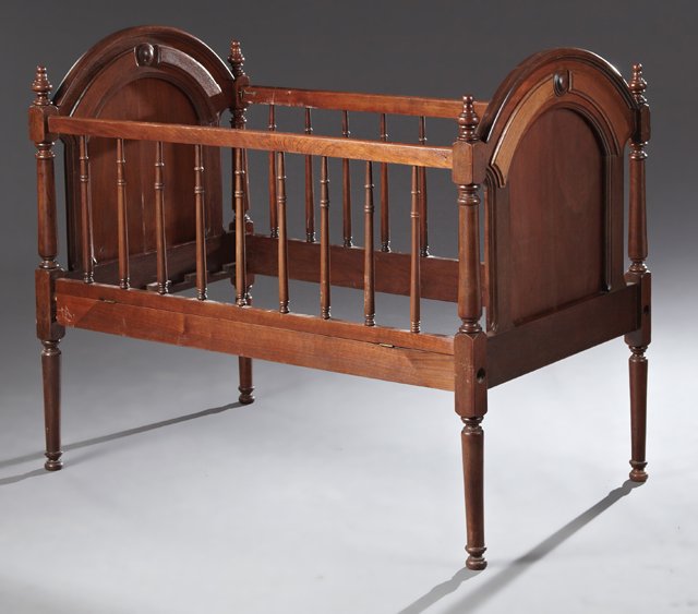American Victorian Carved Mahogany Crib, c. 1880, the: American Victorian Carved Mahogany Crib, c. 1880, the arched head and footboards on turned tapered supports with like legs joined by spindled rails, one with a fall front, H.- 39 1/4 in., Int. W.- 24 