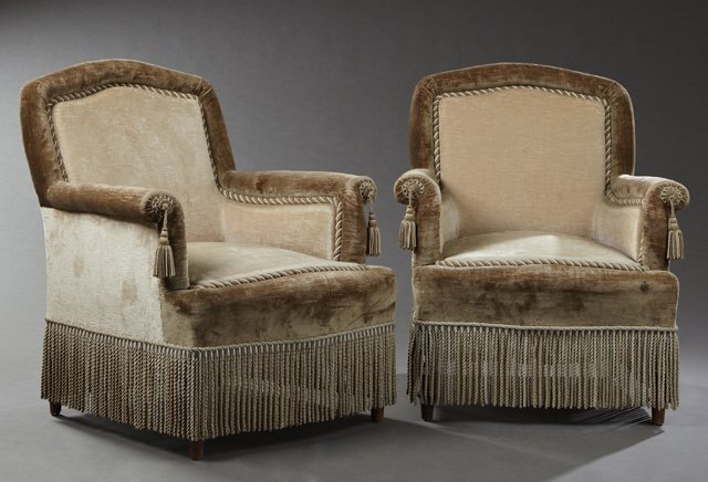 Pair of Late French Empire Style Carved Birch Bergeres,: Pair of Late French Empire Style Carved Birch Bergeres, c. 1870, the arched backs over bowed seats flanked by outwardly scrolled arms, over a seven inch boullion skirt, on ring turned tapered legs, in