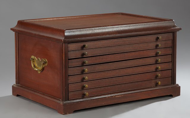 Carved Mahogany Collector's Cabinet, 20th c., the ogee: Carved Mahogany Collector's Cabinet, 20th c., the ogee top over four shallow and one deep drawer with brass knobs, the sides with folding brass handles, H.- 11 3/4 in., W.- 20 1/2 in., D.- 14 3/4 in.