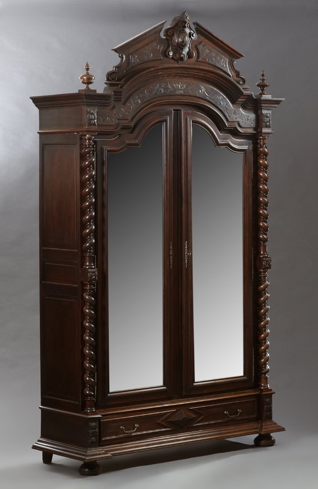 French Louis XIII Style Carved Mahogany Armoire, late: French Louis XIII Style Carved Mahogany Armoire, late 19th c., the broken arch crest crown above two arched wide beveled mirrored doors with short steel escutcheons and short steel fiche hinges within