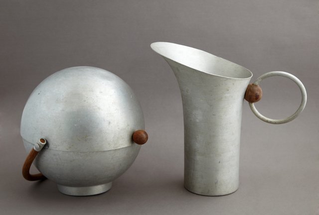 Russel Wright Mid Century Modern Spun Aluminum Pitcher: Russel Wright Mid Century Modern Spun Aluminum Pitcher and Bun Warmer, c. 1950, with wooden accents, Pitcher- H.- 10 1/8 in., W.- 10 3/4 in., D.- 6 1/8 in.