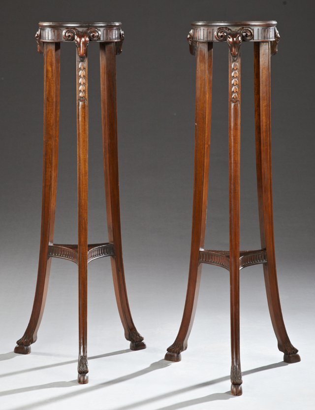 Pair of Carved Mahogany Louis XVI Style Pedestals, 20th: Pair of Carved Mahogany Louis XVI Style Pedestals, 20th c., the stepped circular top on cabriole legs with rams' head surmounts and hoof feet, joined by a lower triangular shelf, H.- 45 1/2 in., Dia.-