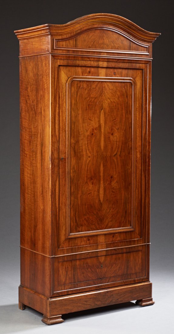 French Louis Philippe Carved Walnut Bonnetiere, 19th: French Louis Philippe Carved Walnut Bonnetiere, 19th c., the stepped arched crown over a paneled door above a lower drawer and a bottom "secret" drawer, on a plinth base on ogee block feet, H.- 81 in.
