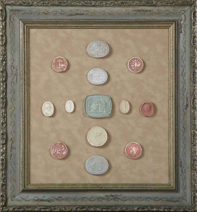 Group of Thirteen Plaster Intaglios, 19th c., Grand: Group of Thirteen Plaster Intaglios, 19th c., Grand Tour Souvenirs, presented in a blue, silver gilt and ecru velvet shadowbox frame, H.- 13 7/8 in., W.- 12 1/2 in.