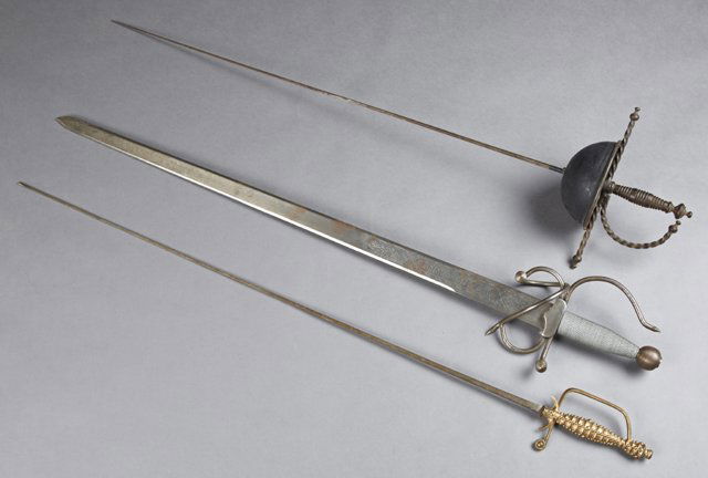 Three Swords, 20th c., consisting of a French epee; a: Three Swords, 20th c., consisting of a French epee; a Spanish Toledo reproduction of El Cid's broadsword; and a brass handle epee, El Cid- H.- 40 in., W.- 6 in., D.- 4 1/8 in. (3 Pcs.)