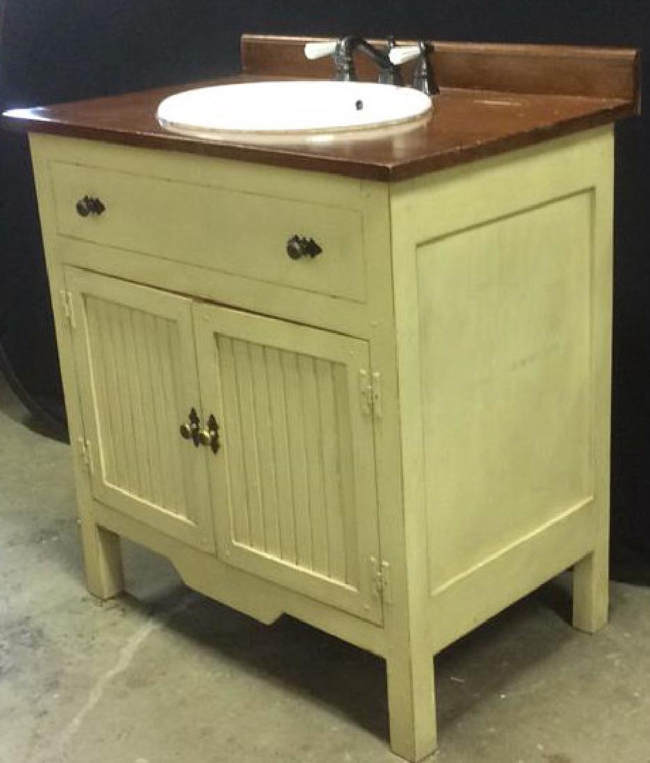 COUNTRY WILLOW Bathroom Vanity Upcycled: New Porcelain Sink with New Pegasus brand Metal and Porcelain Handled Fixtures installed in double door wood painted and varnished distressed cabinet with upper faux front drawer. Cream colored Cabine