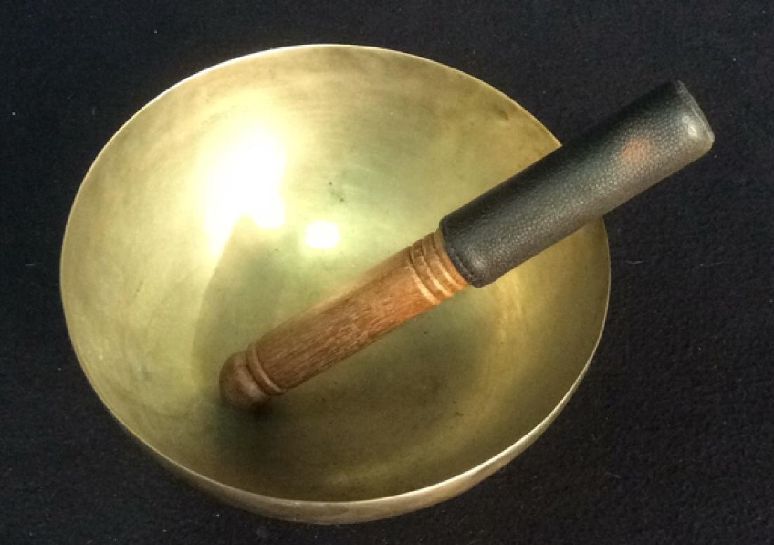 Hand Hammered Ohm Singing Bowl with Striker Hand: Hand hammered metal singing bowl with cushioned hand striker produces meditative vibrating singing harmonics, ideal for calming and meditation. Measures approx 4 inches high and approx 9 inches in dia