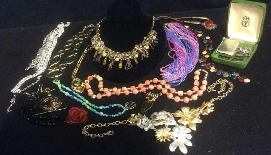 Lot of Contemporary Costume Jewlery Pendant with: Pendant with matching earrings, leather string necklace with carnelian cabachon, art pewter brooch with lavender center piece made in Scotland, choker with rhinestones, Robert Rose necklace and more. 