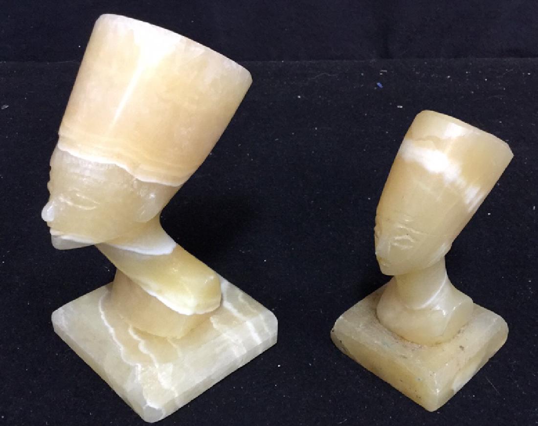Two Alabaster Nefertiti heads 2 hand carved alabaster: 2 hand carved alabaster Nefertiti heads. One measures approx 5.5 inches H x 3 inches W x 3 inches D. The other measures approx 4.5 inches H x 2.25 inches W x 2.25 D.