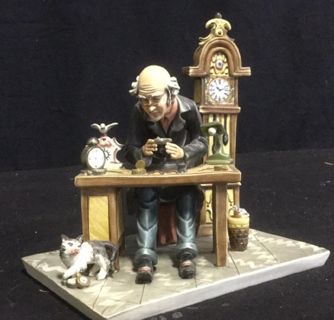 Sonia Porcelain Watchmaker Sculpture Signed: Sonia Porcelain Watchmaker Sculpture, very detailed depiction of man working on clocks with cat at feet; numbered and signed on top side, back left corner, marked on underside for Italy. Measures appr