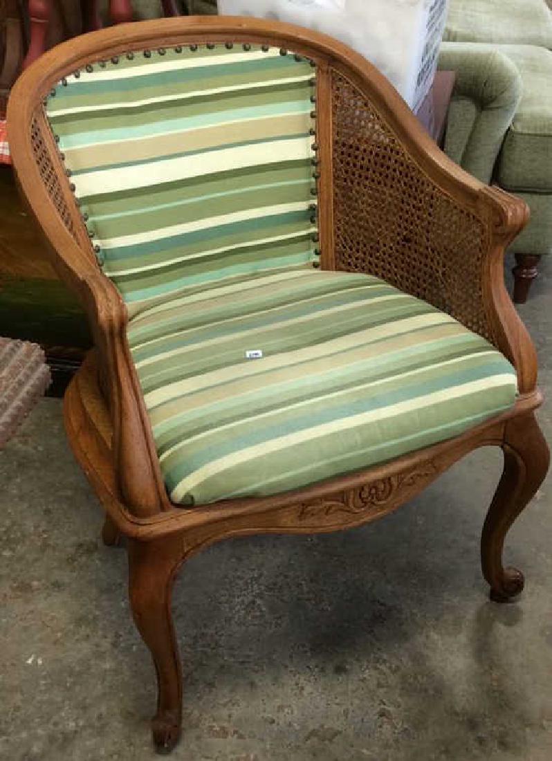 Caned Fruitwood Bergere Arm chair: Country French arm chair in C Form carved apron, cabriole legs. Newly upholstered striped greens with nail head trim. Measures ht 31 width 24 inches, depth 18 inches. Good Condition property of Brookl