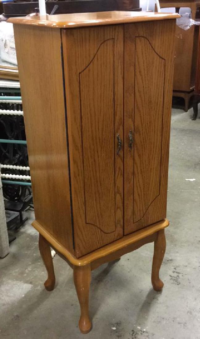 Standing Two-Door Jewelry Cabinet: Top flips up to felt-lined ring and jewelry holder; mirror affixed to underside. Two cabinet doors open to four felt-lined drawers and side hooks. Base on short cabriole legs. Measures: height 40", su