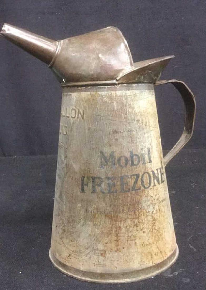 Vintage One-Gallon Mobile Freezeone Can w Spout: Vintage, one gallon, Mobil Freezone tin can with spout and handle, marked with advertising info and embossed with gallon size. Measures approx 11 inches tall and approx 11 inches wide.
