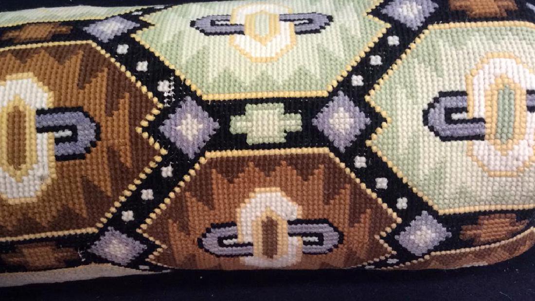 Upholstered Needlepoint Bolster Pillow: Brown greens and creams geometric patterned Bolster Pillow. Good Condition but Velvet End needs re attachment. Measures length 35 inches diameter app 7 inches. Property of Bedford Estate designed by C