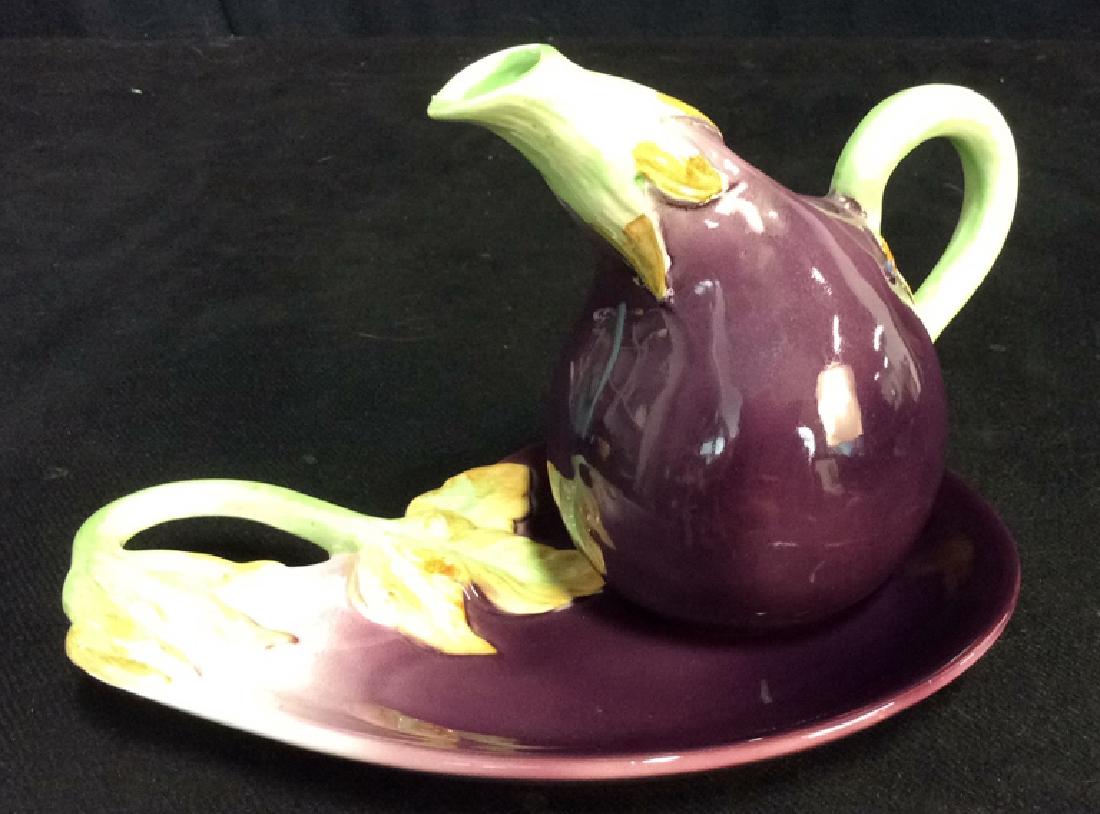 FITZ & FLOYD 2-Piece Eggplant Form Pitcher w Plate: Marked for FITZ & FLOYD on underside. Pitcher has some small chips/wear and measures approx 5 1/2 inches high, plate measures approx 9 inches long.