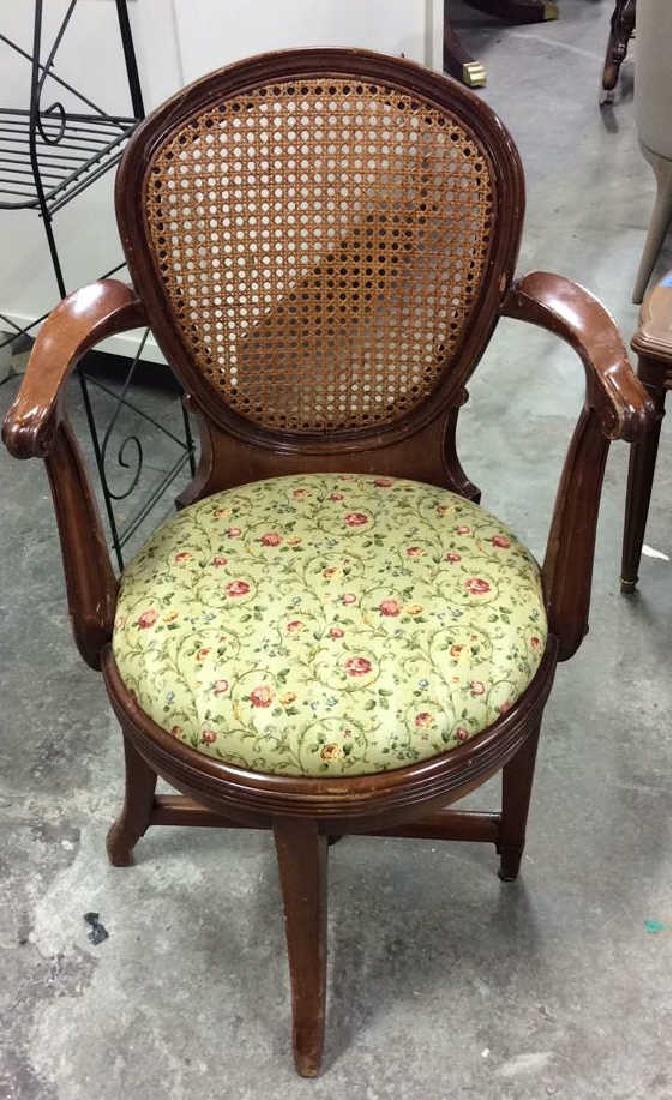 Vintage Caned Back Floral Seat Armchair: Vintage wooden armchair with floral seat and geometric caned back. Chair appears to have swivel feature with additional piece, and top separates from bottom. Left arm has been repaired. Measures appro