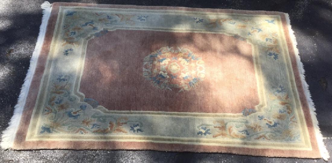 Wool Rug Made In Nepal: Floral motif detailed with pink, slate, and cream tones w fringe. Label reads 100% wool made in Nepal. Measures approx 47 inches wide, 70 inches long.