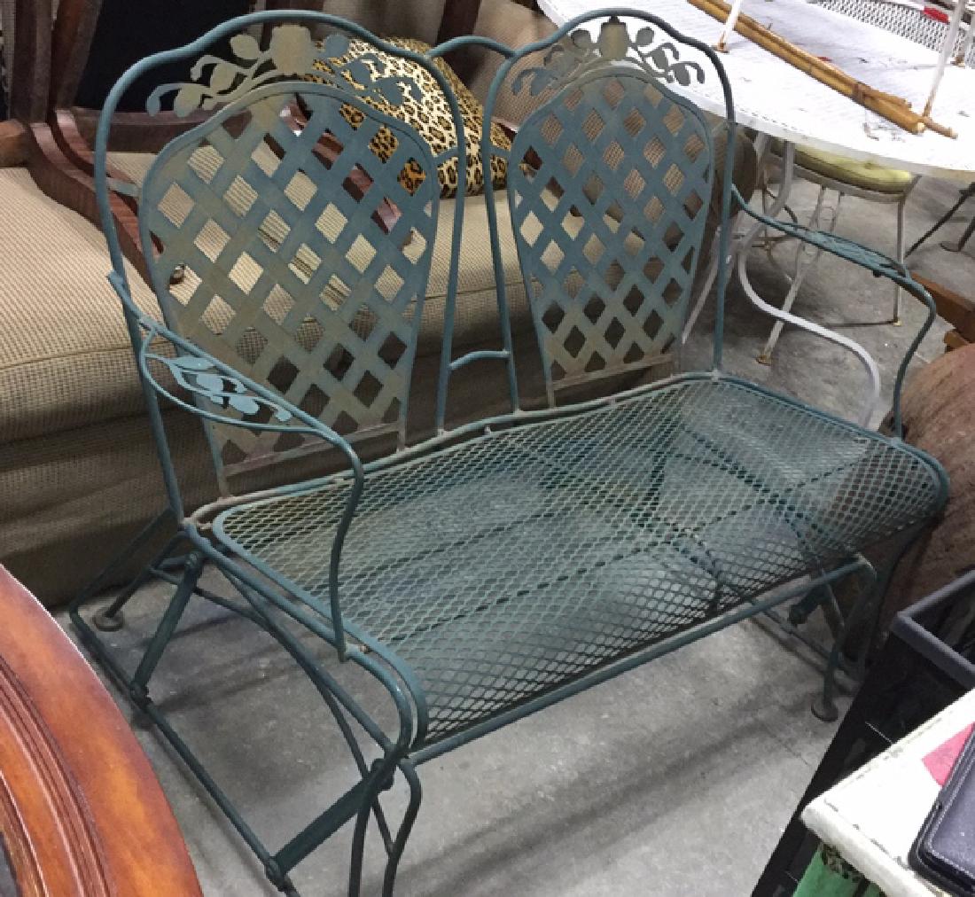 Vintage Outdoor Iron Love Seat Glider: Green wrought iron outdoor glider, loveseat size, lattice-style back and floral design on back and arms. Measures approx 36 inches H x 50 inches W x 27 inches D. Some rust and surface wear. Sofa, sete