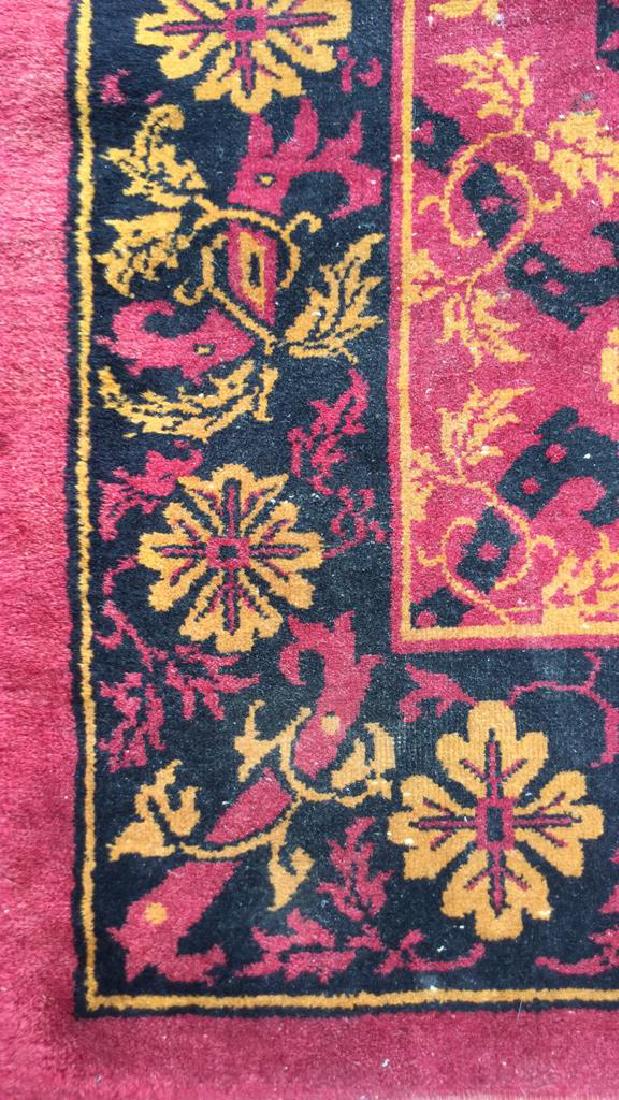 SHEHADI SEAGIRT Turkish Wool Rug: Vintage possibly Antique Label reads SHEHADI SEAGIRT. Turkish rug with faded cranberry, black & orange tones. Floral motif detail. Wear to edges, some sun fading 7 inch hole in corner. Measures approx