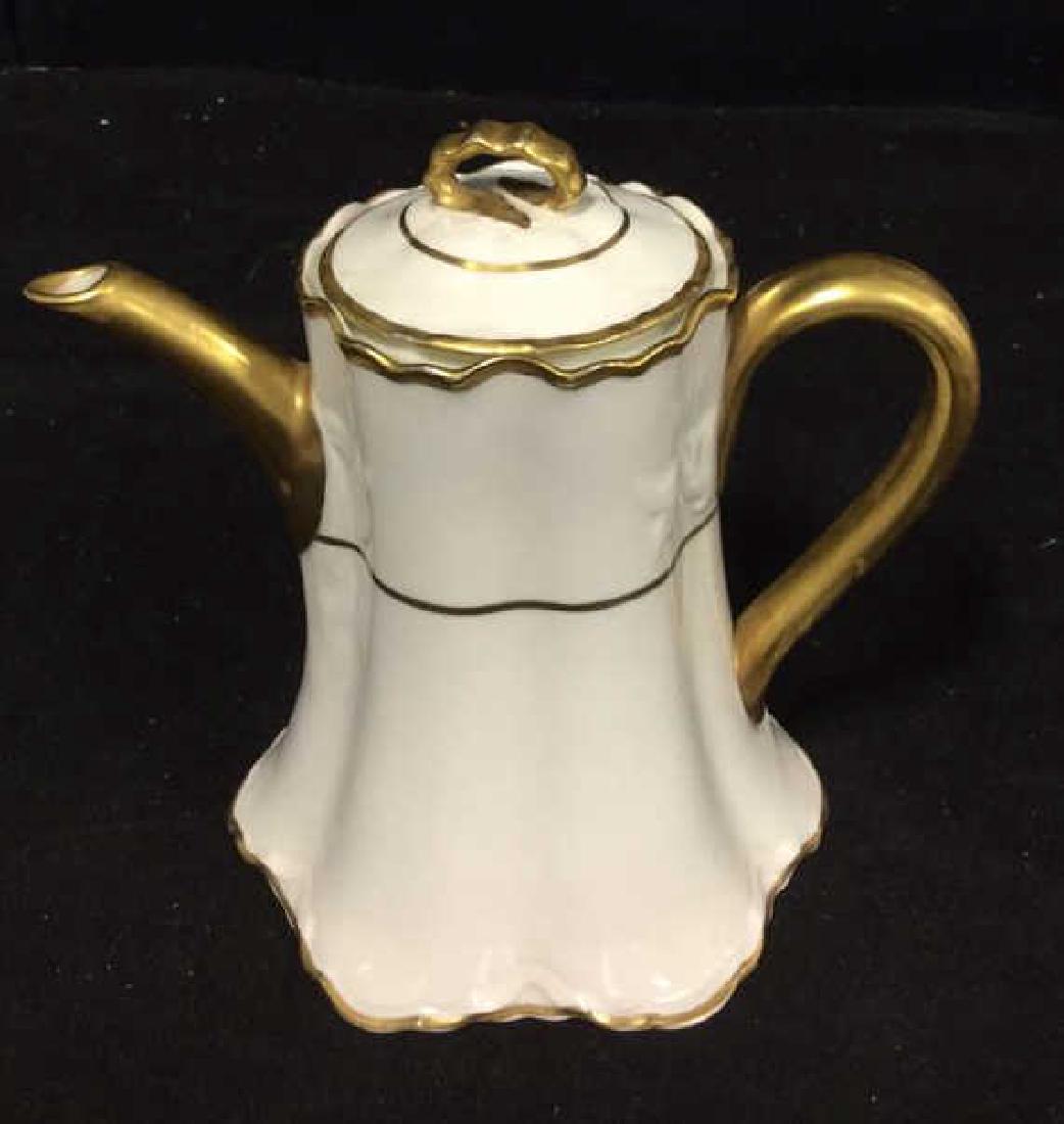 Pope Gosser Pearl White China Tea Pot w Lid: Pope Gosser pearl white china teapot w lid. Painted gold toned detailing with raised ribbon motif. Stamped Pope Gosser China made in USA ON Bottom. Slight chip on lid and minor wear on gold toned pain