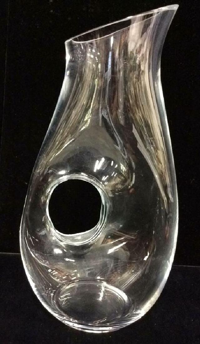 Glass Pitcher Streamlined Modernist: Glass pitcher with negative space handle, streamlined modern design. Minimalist design with 1/4 in thick glass. Pitcher measures approx 12 in tall by 6 1/2 in long by 4 in wide.
