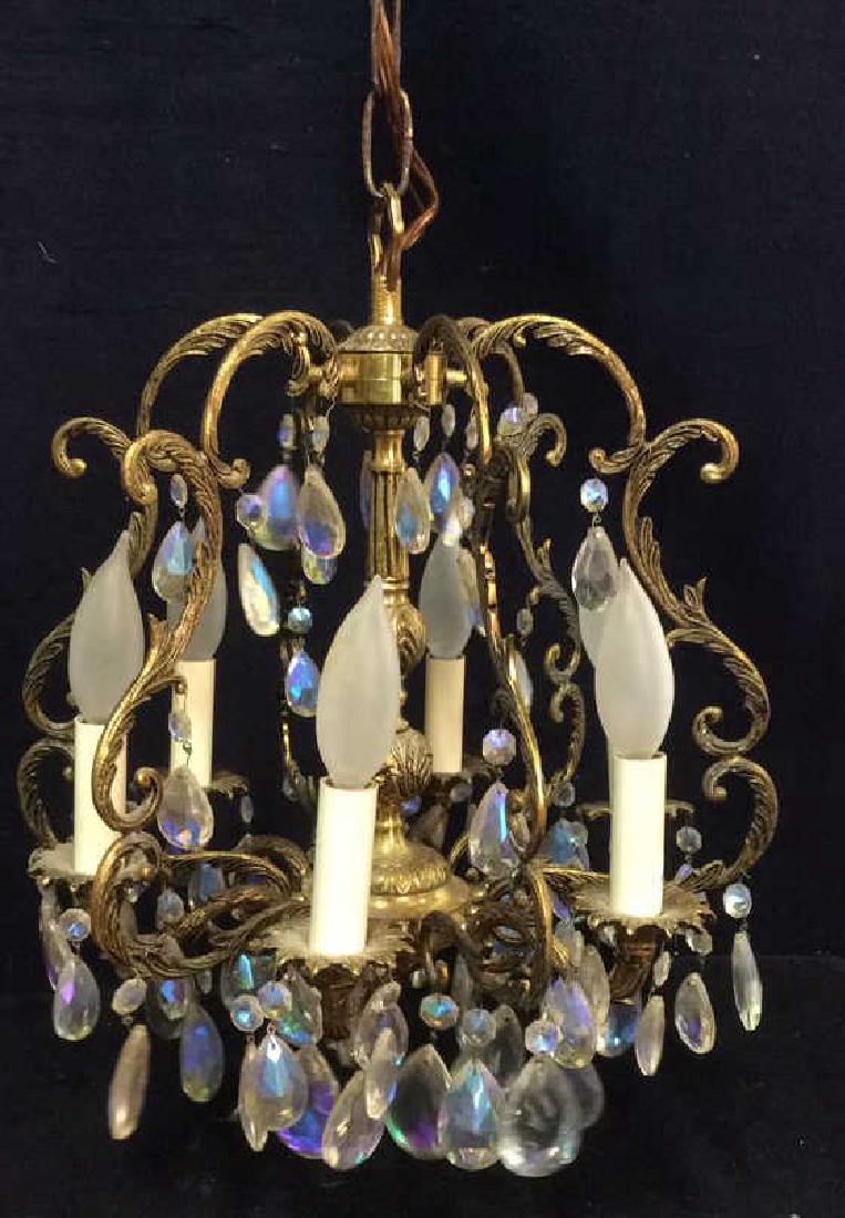 Gold Toned Ornate Teardrop Chandelier: Gold Toned Ornate Teardrop Chandelier. Contains 6 arms ornate C and S curve detail along with leaf and vine detail. Teardrop details have pearlescent toned detail. Measures approx 32 inches tall hangi