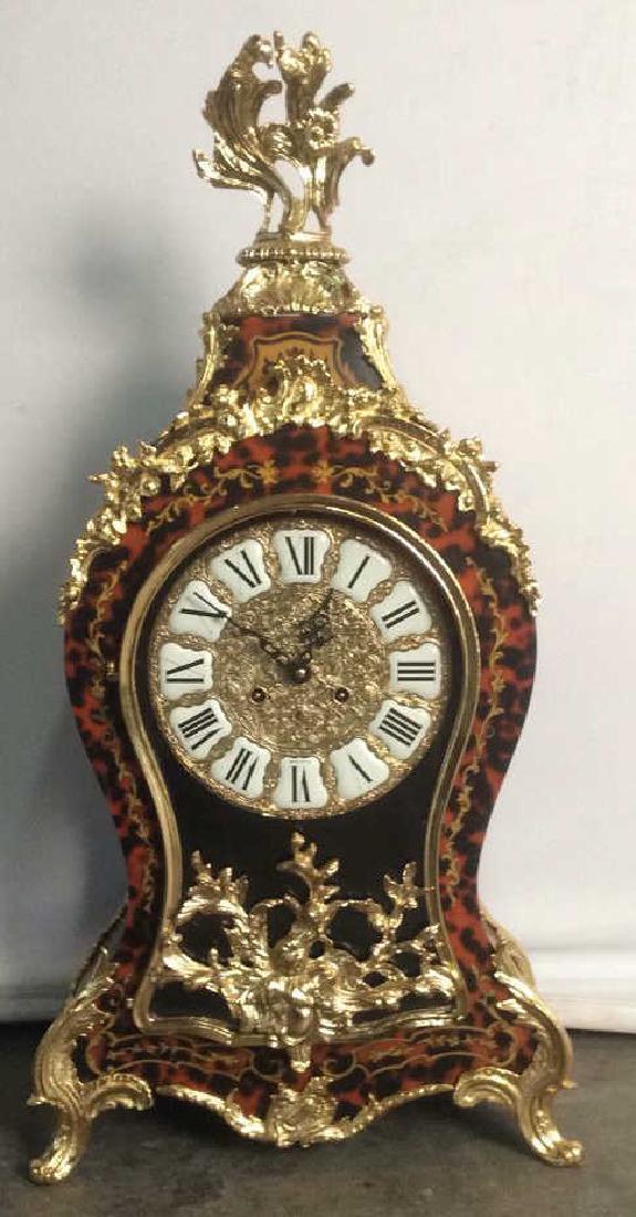 Italian Wood Ormolu Ornately Detailed Clock: Louis XV Style, Ornate possibly gold leaf detailed Mantle clock. Marquetry Veneer, Gold toned ornately bordered glass door opens to roman numeral ornate gold and white tone clock face. Marked made in 