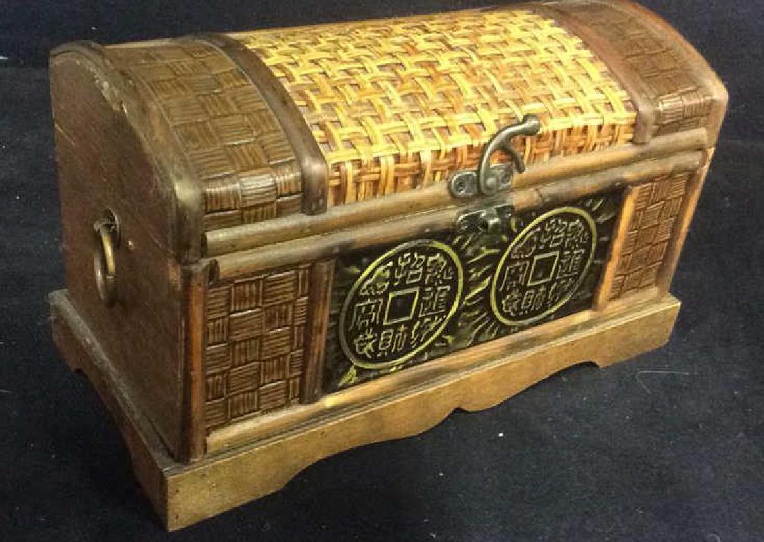 Wooden Jewelry Trinket Chest: Contains Gold toned medallion detail on front with Asian Characters. Intricately carved wooden geometric detail. Caning on lid. Has gold toned loop style handles. Some minor chips and surface wear. Me